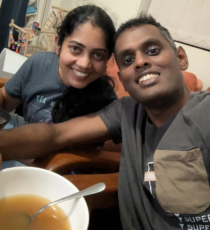 Nipuna and Chathu smiling together over a bowl of chicken broth — the first meal after a 5-day fast
